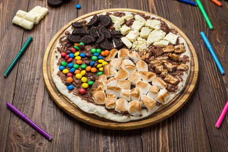 sweet pizza with chocolate and marshmallow on wooden backgroundの写真素材