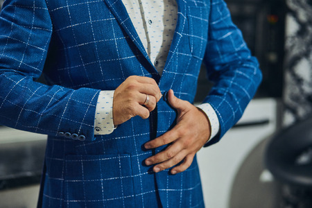 Businessman wears a jacket,male hands closeup,groom getting ready in the morning before wedding ceremonyの写真素材