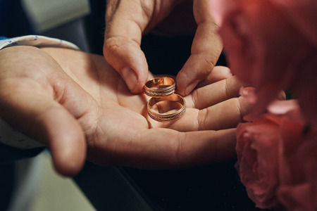 man holding wedding rings, groom getting ready in the morning before ceremony