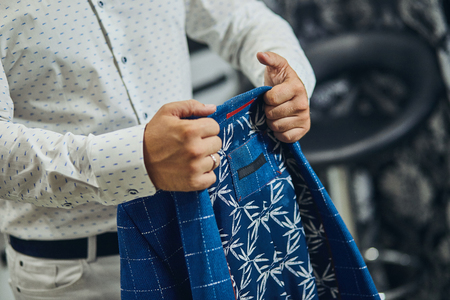 Businessman wears a jacket,male hands closeup,groom getting ready in the morning before wedding ceremonyの写真素材