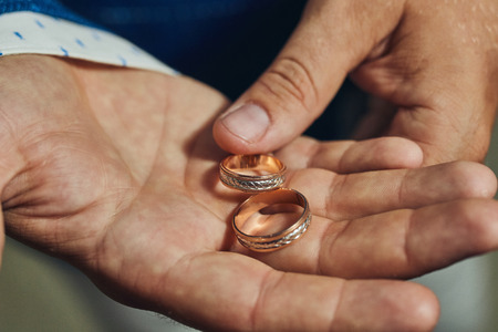 man holding wedding rings, groom getting ready in the morning before ceremonyの写真素材