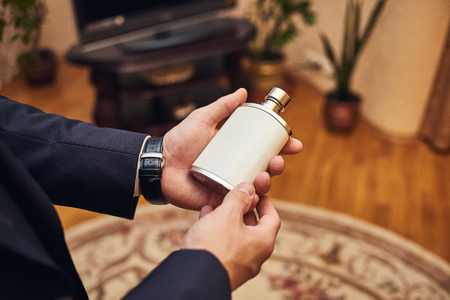 Handsome guy is choosing perfumes, Elegant man in suit using cologne,groom getting ready in the morning before wedding ceremony. Men Fashionの写真素材