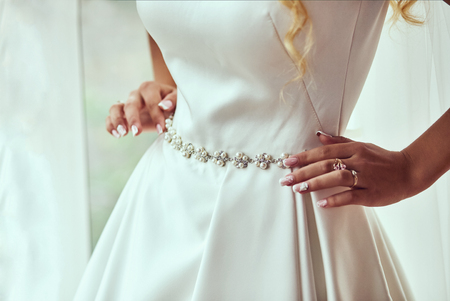 Morning of the bride when she wears a beautiful dress, woman getting ready before wedding ceremonyの写真素材