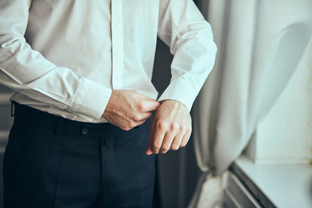 businessman dresses white shirt, male hands closeup,groom getting ready in the morning before wedding ceremony. Men Fashionの写真素材
