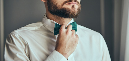 businessman putting on  bow tie,man butterfly clothes,groom getting ready in the morning before...