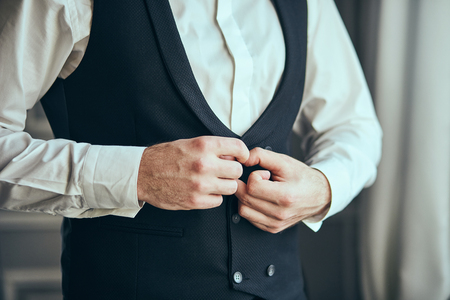 Businessman wears a jacket,male hands closeup,groom getting ready in the morning before wedding ceremony. Men Fashionの写真素材