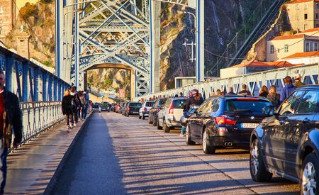 View of the historic city of Porto, Portugal with the Dom Luiz bridge. A metro train can be seen on...