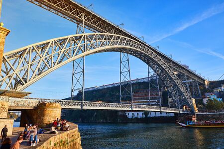 View of the historic city of Porto, Portugal with the Dom Luiz bridge. A metro train can be seen on...