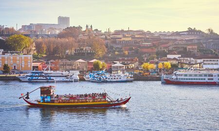 09 of December, 2018 - Porto, Portugal: Boats on Douro river with view on  Red roofs of side Villa Nova de Gaia  in Porto. Concept of world travel, sightseeing and tourismのeditorial素材