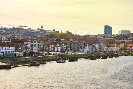 Typical portuguese wooden boats, called "barcos rabelos" transporting wine barrels on the river Douro with view on Villa Nova de Gaia  in Porto, Portugalの写真素材