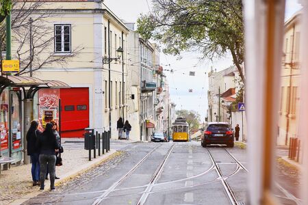 LISBON, PORTUGAL, 12, December, 2018: Wooden historical vintage yellow street tram 28 moving through...