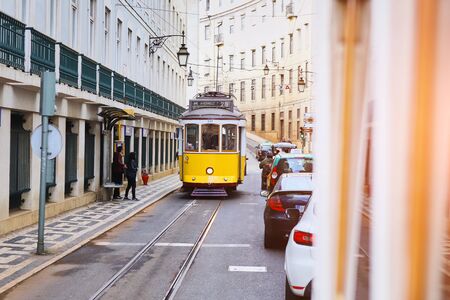 LISBON, PORTUGAL, 12, December, 2018: Wooden historical vintage yellow street tram 28 moving through Lisbon, symbol of city. Indispensable transport for locals and interesting attraction for touristsのeditorial素材