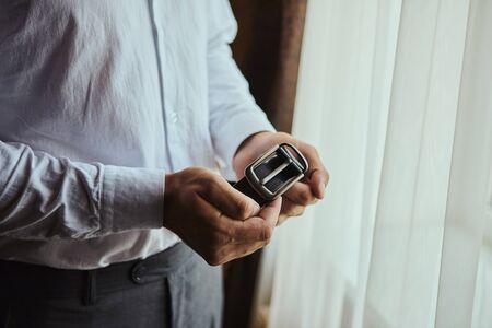 Businessman putting on a belt, fashion and clothing concept,groom getting ready in the morning before ceremonyの写真素材