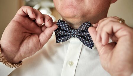 businessman putting on  bow tie,man butterfly clothes,groom getting ready in the morning before...