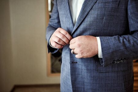 Businessman wears a jacket,male hands closeup,groom getting ready in the morning before wedding ceremonyの写真素材