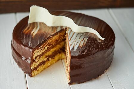 Dark chocolate vegan cake with candies and nuts on wooden backgroundの写真素材