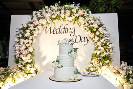 wedding festive multi-storey cake in white tone decorated with beautiful flowersの写真素材