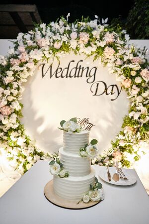 wedding festive multi-storey cake in white tone decorated with beautiful flowersの写真素材