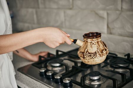 girl brews coffee in turk