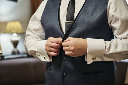 Businessman wears a jacket,male hands closeup,groom getting ready in the morning before wedding...