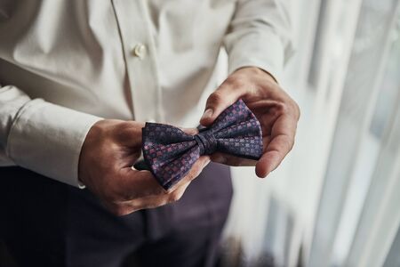 businessman putting on  bow tie , man butterfly clothes,groom getting ready in the morning before...