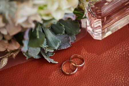 wedding rings lie near the bouquetの写真素材