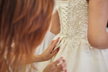 Morning of the bride when she wears a beautiful dress, woman getting ready before wedding ceremony