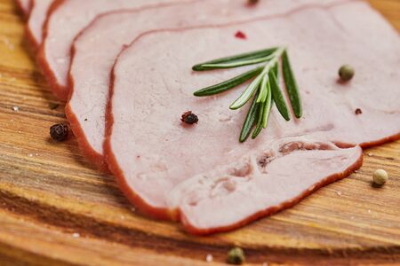 Sliced ham with spices, lettuce, avocado and tomatoes on wooden cutting board. Ð¡old meat plate. Fresh prosciuttoの写真素材
