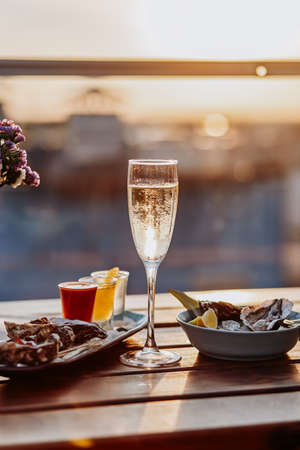 Fresh open oysters with a glass of chilled prosecco wine and set of shoot alcoholic cocktails served on table. Seafood deliciosの写真素材