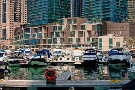 Dubai, UAE - November 06, 2021: Luxury Dubai Marina skyscrapers, cruise boat and promenade in beautiful sunny morning, United Arab Emiratesのeditorial素材