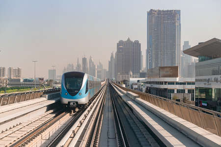 Dubai, United Arab Emirates - November 06, 2021: Dubai metro train on rails at background of...