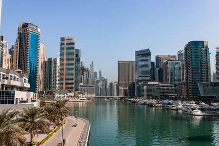 Dubai, UAE - November 09, 2021: Luxury Dubai Marina skyscrapers, cruise boat and promenade in beautiful sunny morning, United Arab Emiratesのeditorial素材