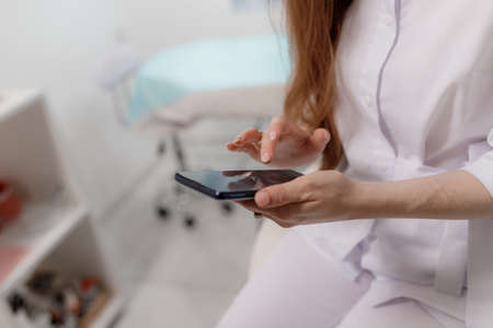 Girl holding mobile phone in handsの写真素材