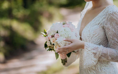 bouquet in hands of the bride, woman getting ready before wedding ceremony