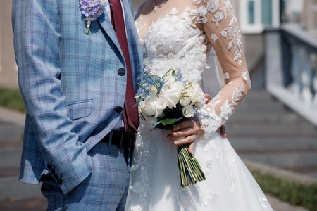 Bride holding a wedding bouquet in the hands standing near groomの写真素材