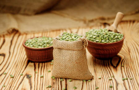 Green pea groats in bowls and bags on a wooden background. High quality photoの写真素材