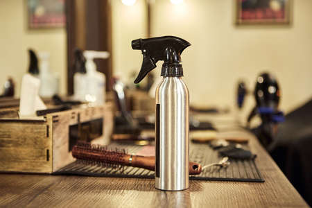 Hairdressing tools. Haircut spray and other tools stand on the table in the barbershopの写真素材