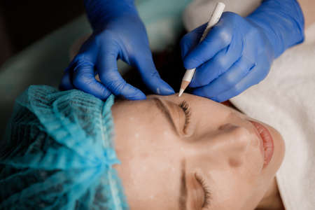 Cosmetologist preparing patient for botox procedure