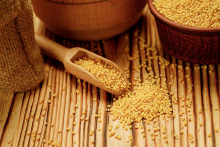 Millet polished in bowls and bags on a wooden background. High quality photoの写真素材