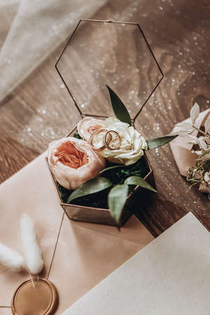 wedding rings lie on a beautiful box with flowers as bridal accessories