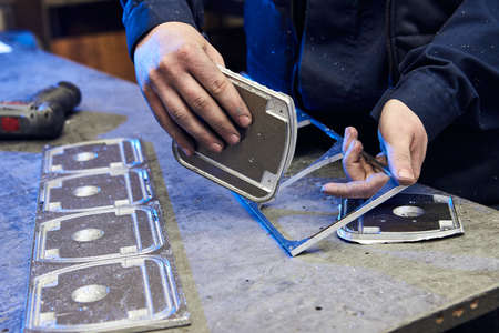 Ð¡raftsman disassembles aluminum blanks of metal profile. Steel industry. Cutting aluminium...