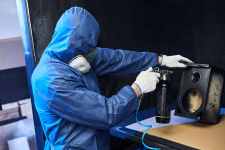 Professional painter works in the paint shop