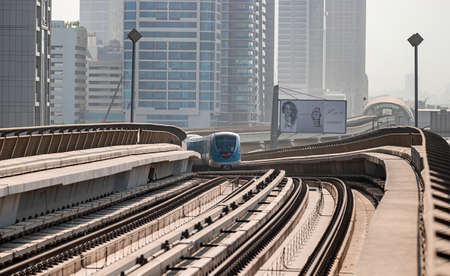 Dubai, United Arab Emirates - November 08, 2021: Dubai metro train on rails at background of skyscrapers. Famous outdoor subway Red Lineのeditorial素材