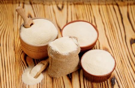 Semolina in bowls and bags on a wooden background. High quality photoの写真素材