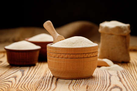 Semolina in bowls and bags on a wooden background. High quality photoの写真素材