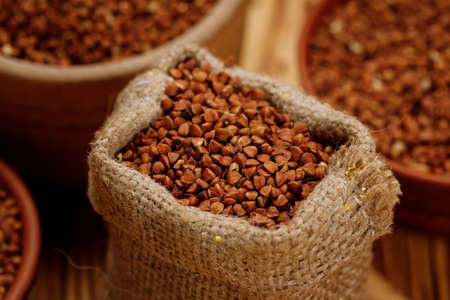 Buckwheat groats in bowls and bags on a wooden background. High quality photo