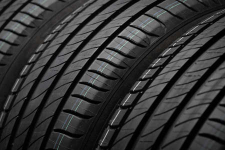 New car tires. Group of road wheels on dark background. Summer Tires with asymmetric tread design....