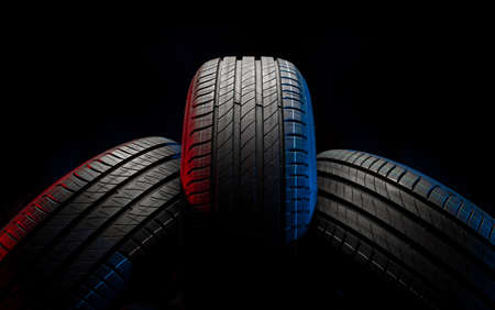 New car tires. Group of road wheels on dark background. Summer Tires with asymmetric tread design. Driving car concept.の写真素材