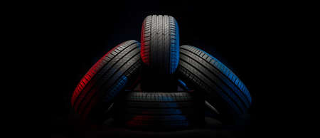 New car tires. Group of road wheels on dark background. Summer Tires with asymmetric tread design....