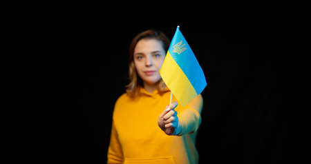 Ukraine national flag. Beautiful ukrainian girl with government flag on a stick in her hands on...